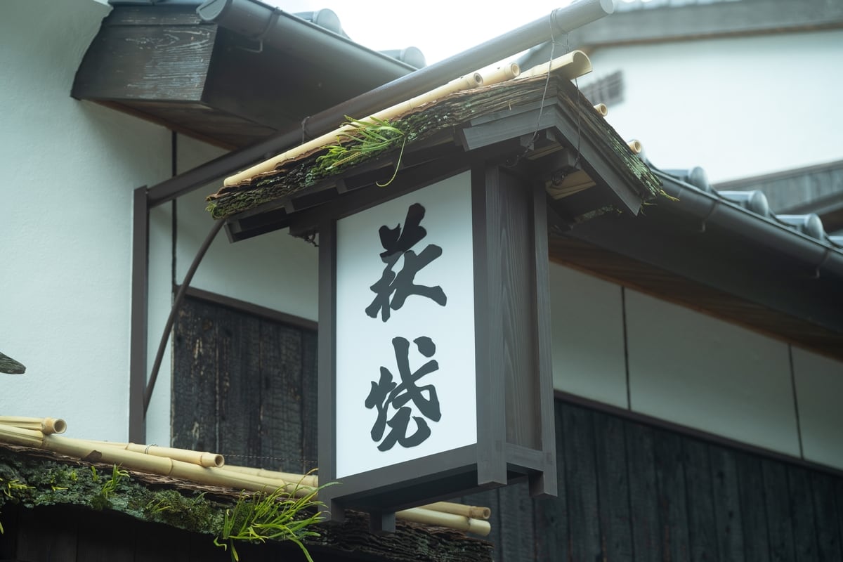 萩焼城下苑の看板も改修。杉皮葺き屋根に生える草や苔はそのままに、木枠をきれいにの写真。