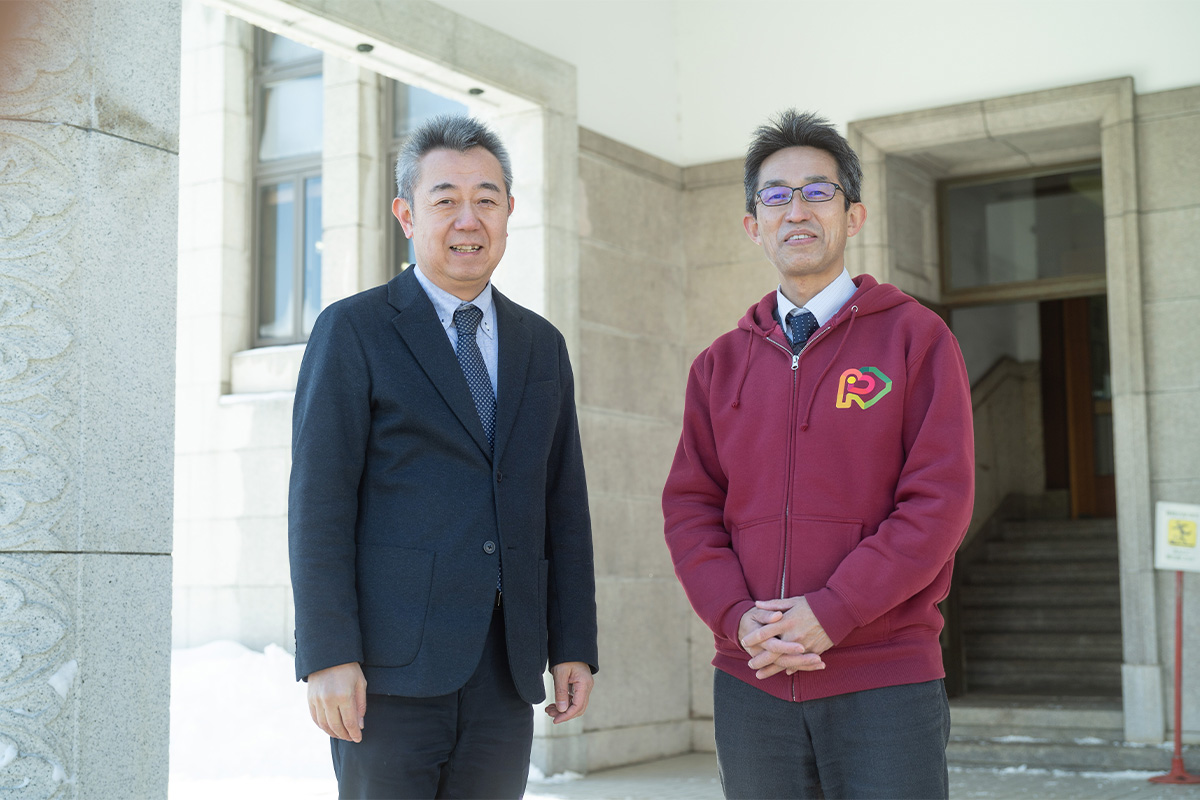 小樽市産業港湾部長・渡部一博さん(左)と産業港湾部観光振興室の松本貴充さんの写真。